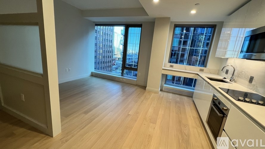 A kitchen with wooden floors and a window overlooking a cityscape.