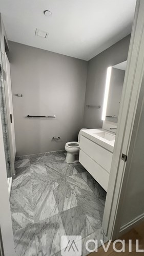 A bathroom with a toilet, sink, and mirror.