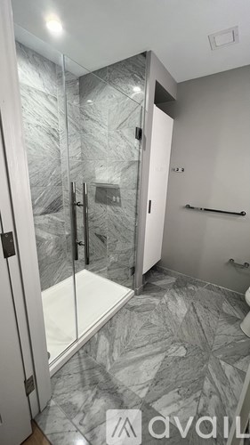 A bathroom with a walk-in shower and marble flooring.