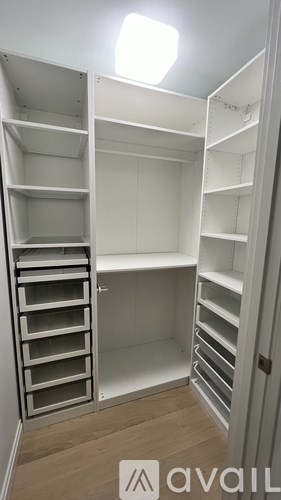 A white walk-in closet with shelves and drawers.