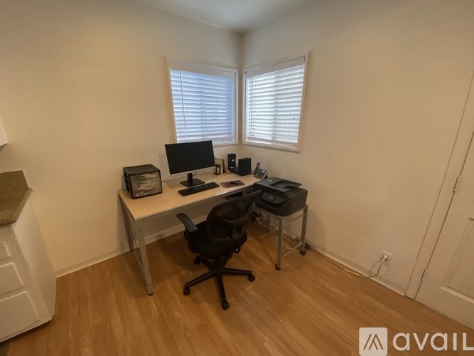 A room with a desk, chair, and computer setup.