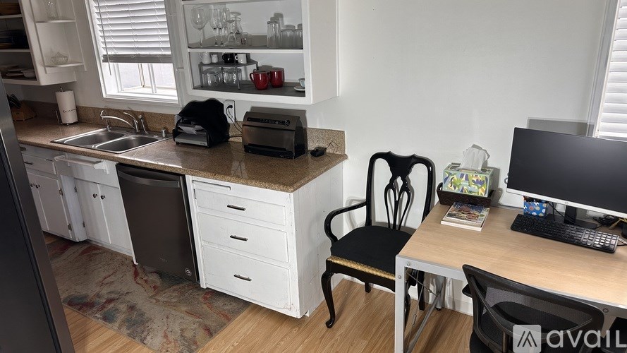 A kitchen with a sink, a dishwasher, and a fridge.