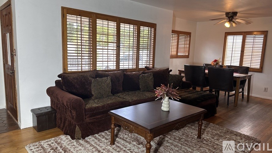 A living room with a brown couch and a wooden coffee table.