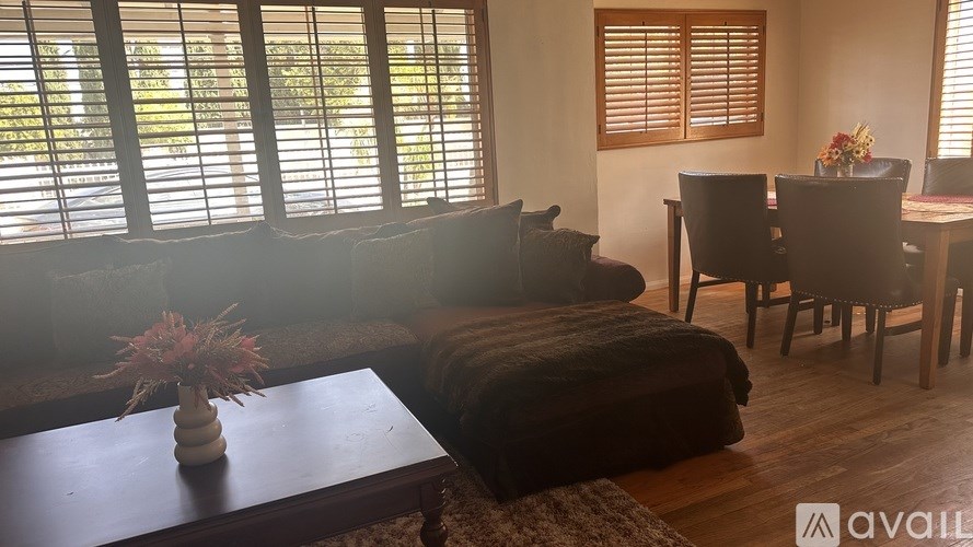 A living room with a couch, chairs, and a coffee table.
