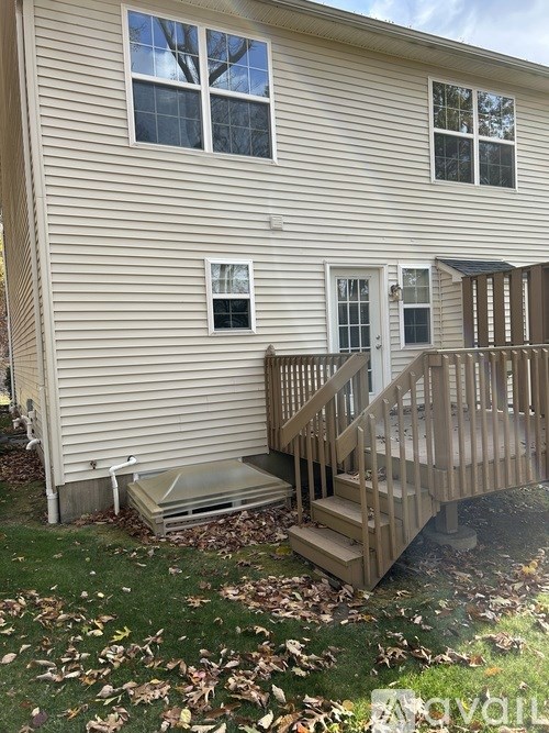 A house with a wooden deck and stairs leading to the front door.