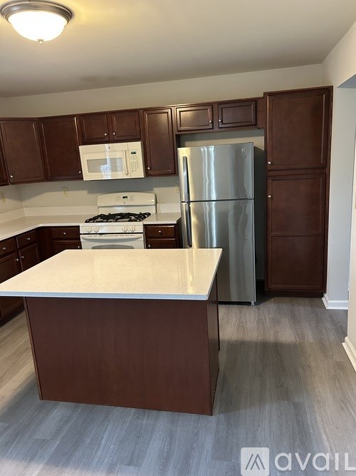 A kitchen with brown cabinets and a white countertop.