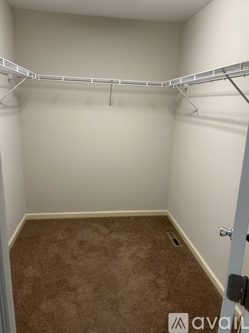 A room with a carpeted floor and a white door.