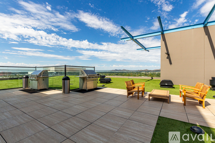 A patio with a table and chairs overlooking a grassy field.