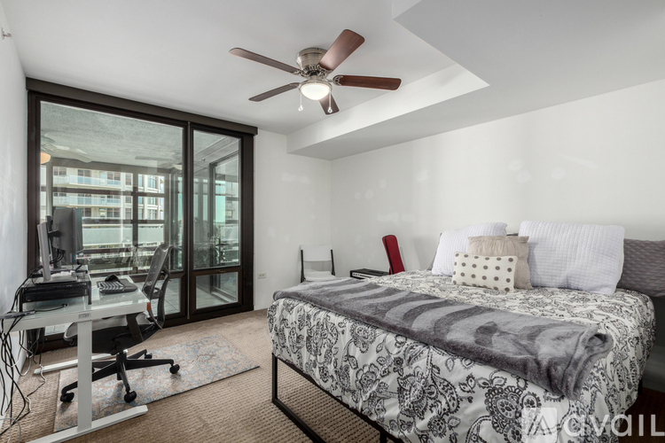 A bedroom with a bed, desk, and chair.