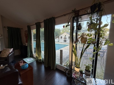 A living room with a brown leather couch and a coffee table with a blue vase on it.