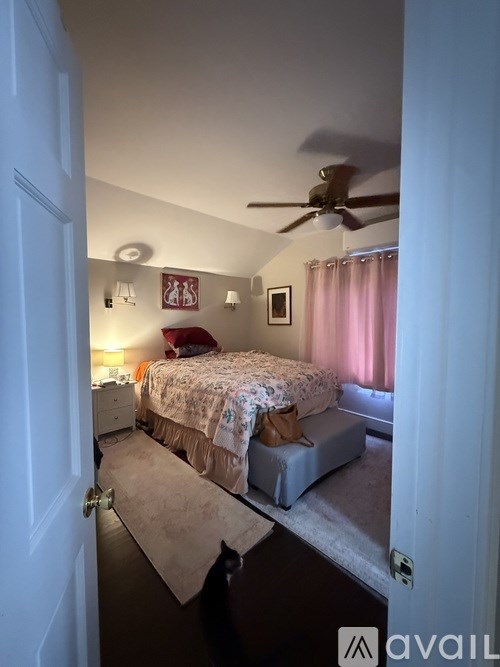 A bedroom with a bed, dresser, and ceiling fan.