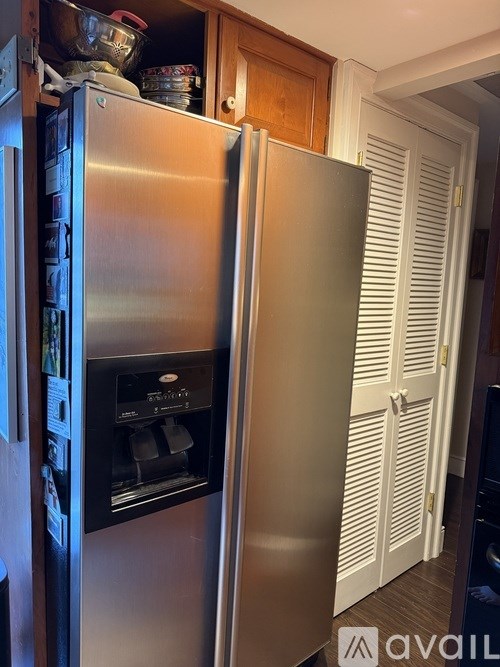 A stainless steel refrigerator with its door open in a kitchen.