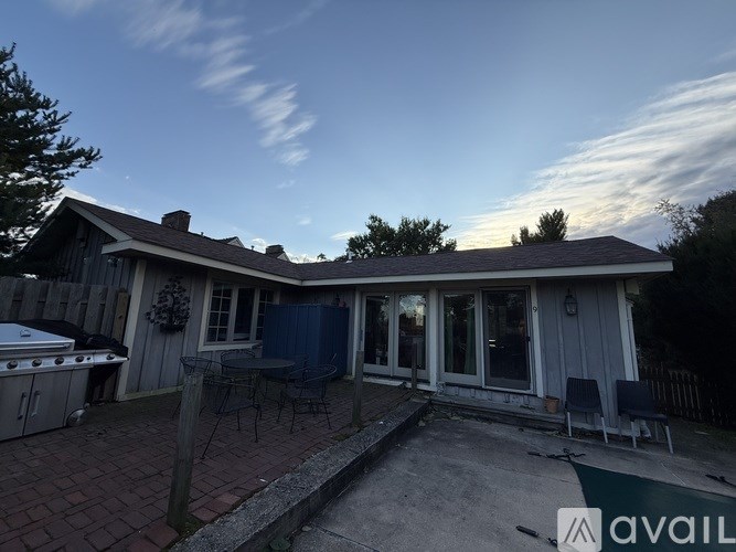A backyard with a patio and a grill.
