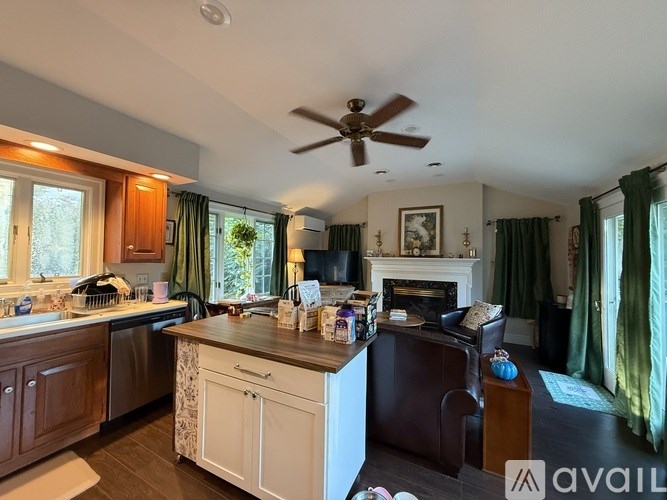 A kitchen with a white ceiling fan and a brown leather chair.