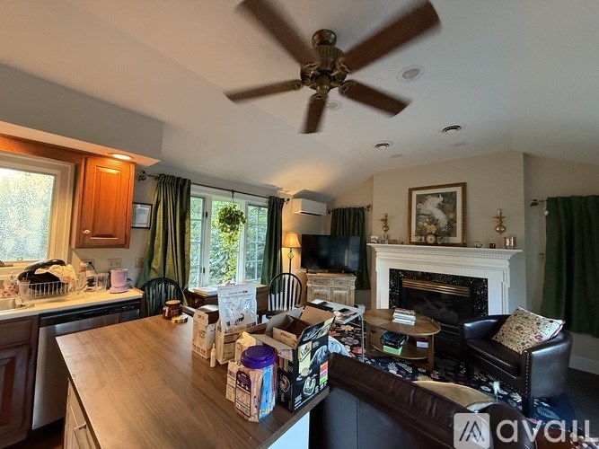 A living room with a fireplace and a dining table.