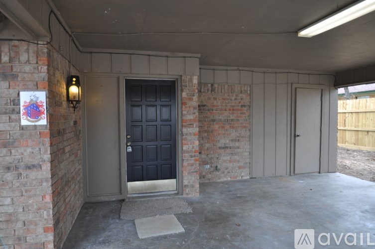 A black door is in the middle of a brick wall.