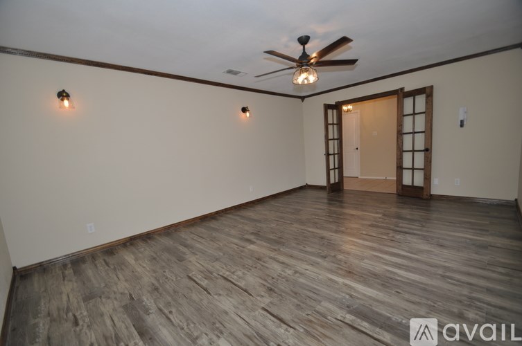 A room with wooden flooring and a ceiling fan.