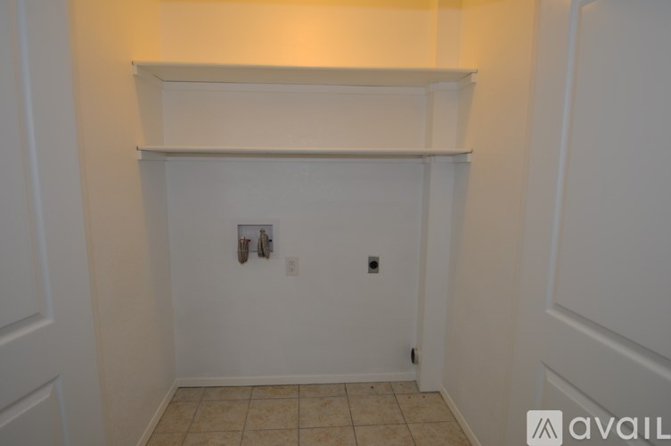 A white wall with a shelf and two switches.
