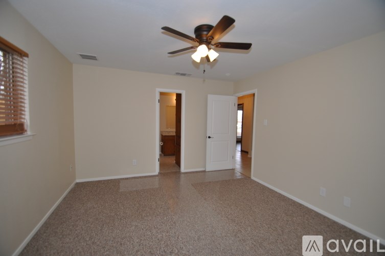 A room with a ceiling fan and carpeted floor.