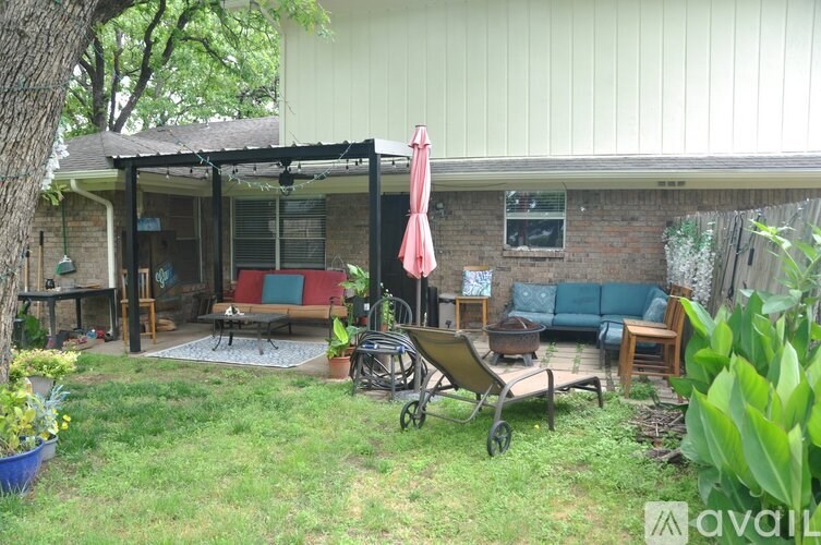 A patio with a table and chairs under a pergola.