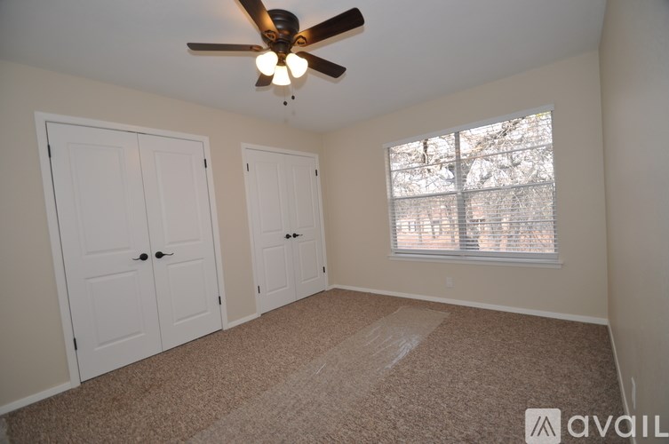 A room with a ceiling fan and two doors.