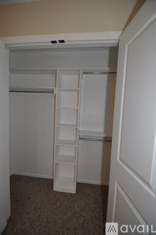 A white closet with shelves and drawers is available.