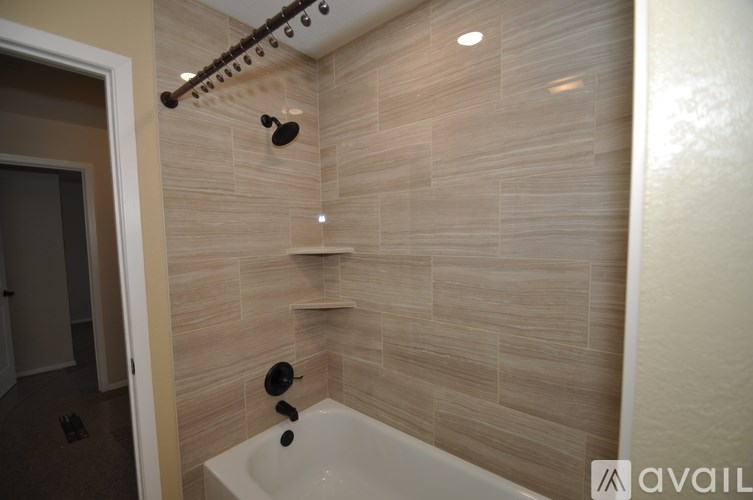 A bathroom with a shower and a tub.