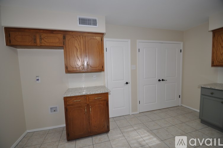 A kitchen with a wooden cabinet and a white countertop.