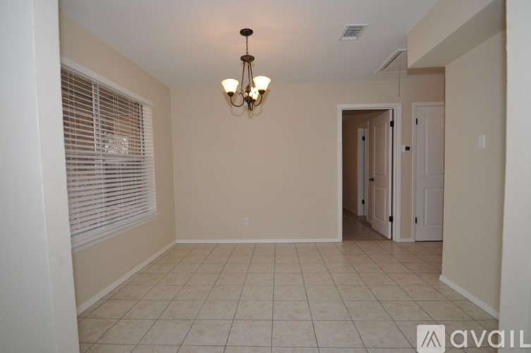 A room with a chandelier and tiled flooring.