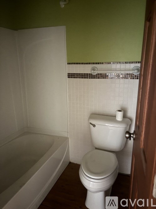A white toilet in a bathroom with green walls.