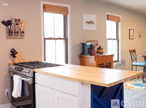 A kitchen with a wooden island and white cabinets.