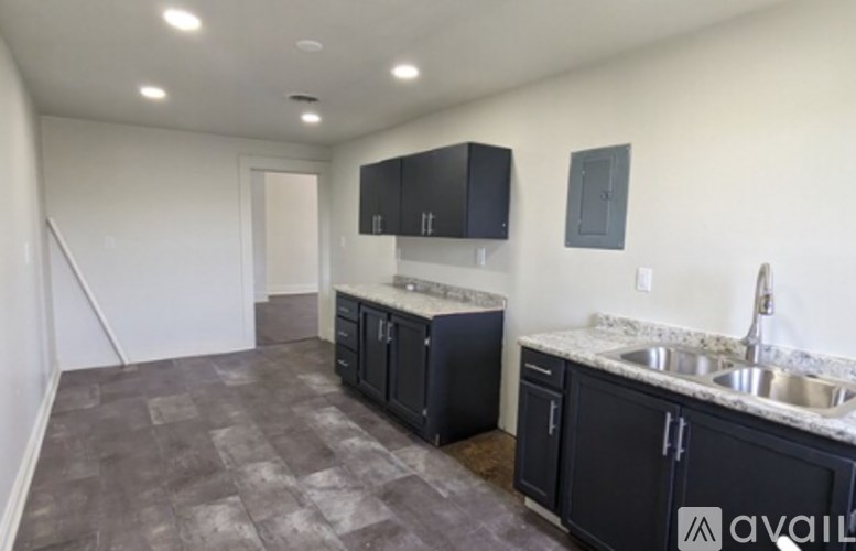 A kitchen with black cabinets and a marble countertop.