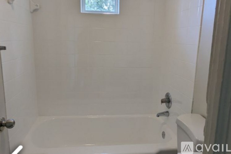 A white bathroom with a tub and toilet.