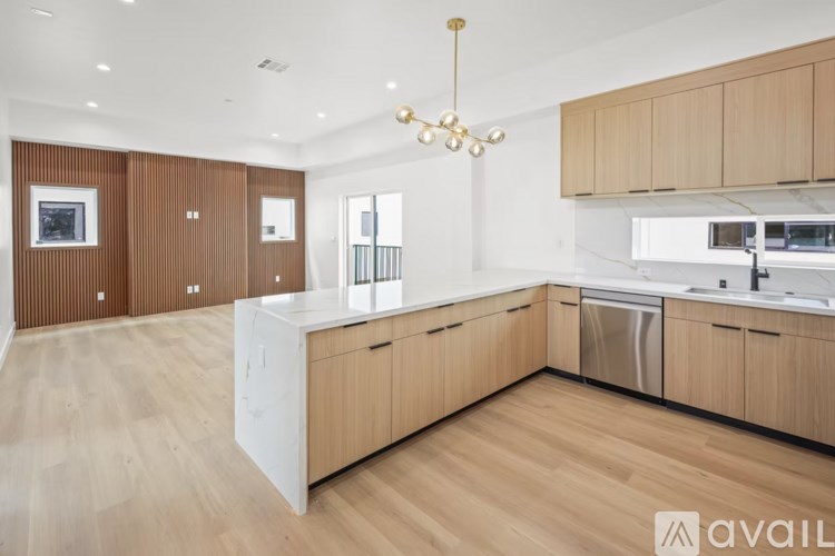 A modern kitchen with wooden cabinets and a white island.
