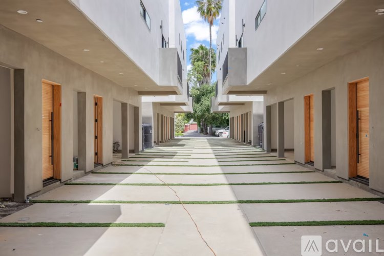 A long, narrow hallway with doors on both sides and a green rug on the floor.