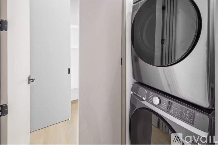 A modern washing machine is placed in a room with a white door.