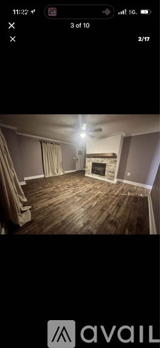 A room with wooden flooring and a fireplace.