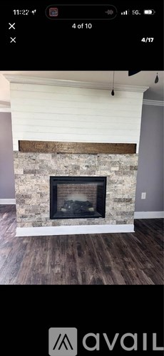 A fireplace with a wooden mantle and a white surround.