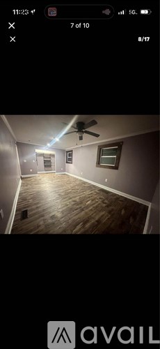 A room with wooden flooring and a ceiling fan.