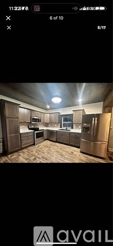 A kitchen with wooden cabinets and a stainless steel refrigerator.