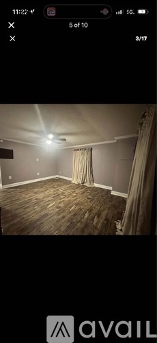 A room with wooden flooring and a curtain.