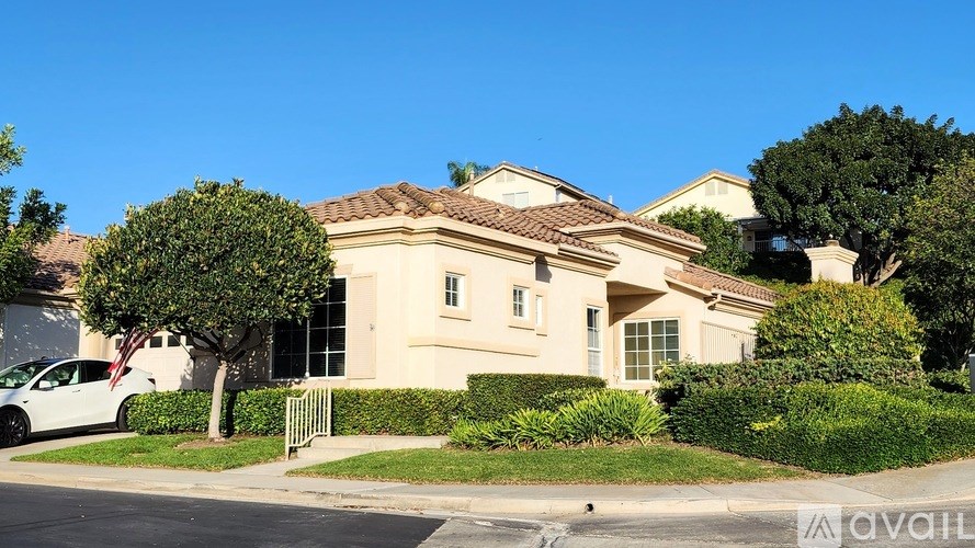 A house with a white car parked in front of it.