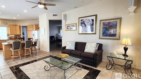 A living room with a glass coffee table and a couch.