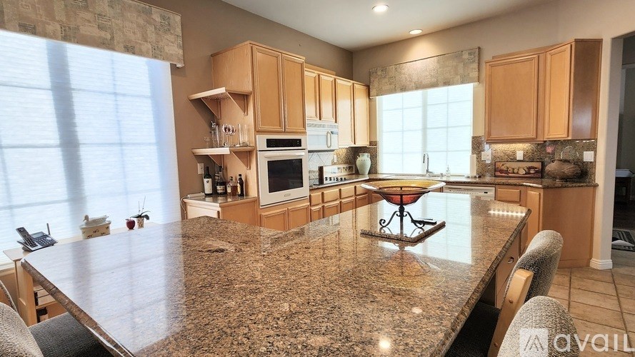A kitchen with granite countertops and wooden cabinets.
