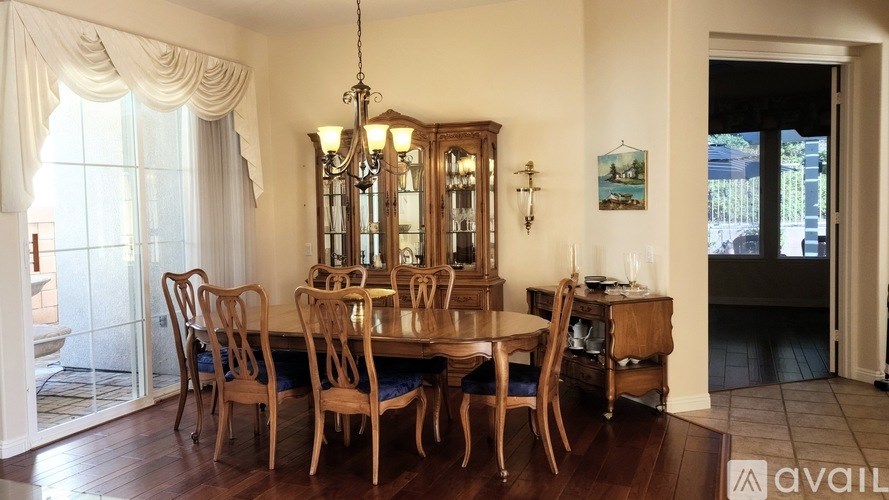 A dining room with a wooden table and chairs.