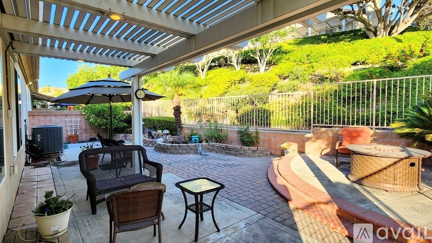 A patio with a table and chairs under a roof.