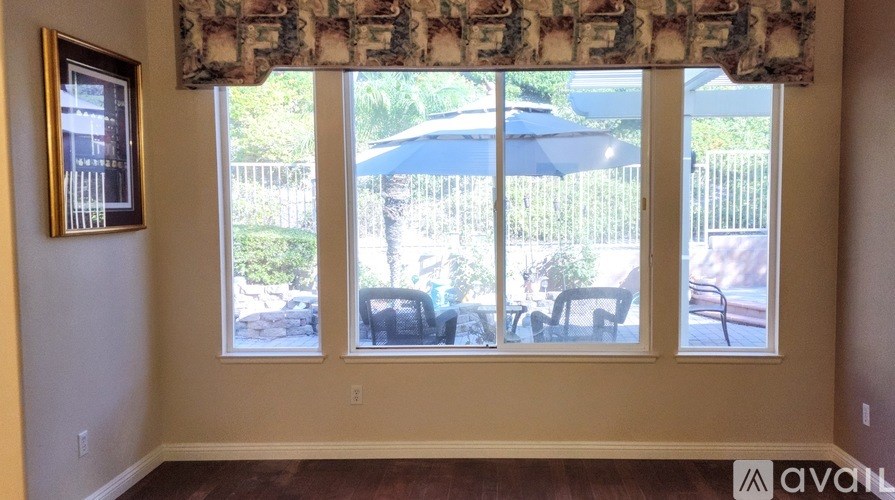 A room with a window overlooking a backyard.
