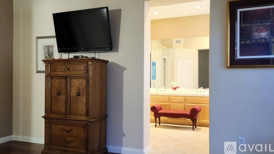 A room with a wooden cabinet and a television on top of it.
