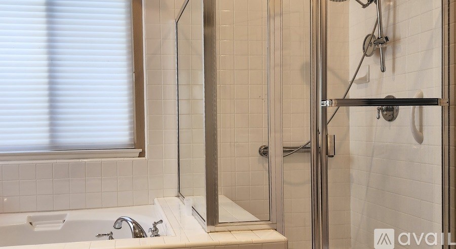 A bathroom with a tub, sink, and shower.
