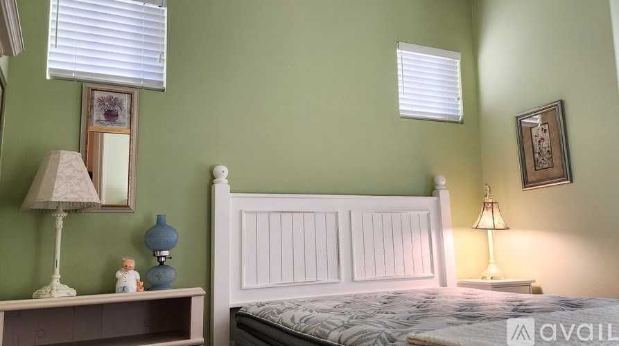 A bedroom with a bed, nightstand, and two lamps.